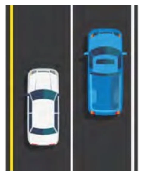 Solid white line separating same-direction traffic lanes before intersection